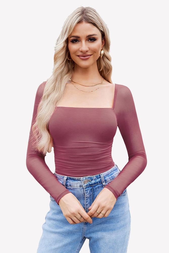 Mauve mesh square neck bodysuit with ruched detail, long sleeve. Model in jeans and gold jewelry.