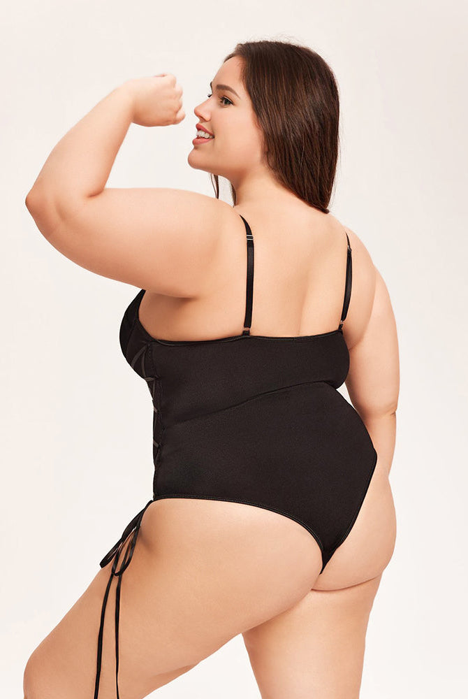 Black tummy control bodysuit with adjustable straps and side tie details on a smiling woman
