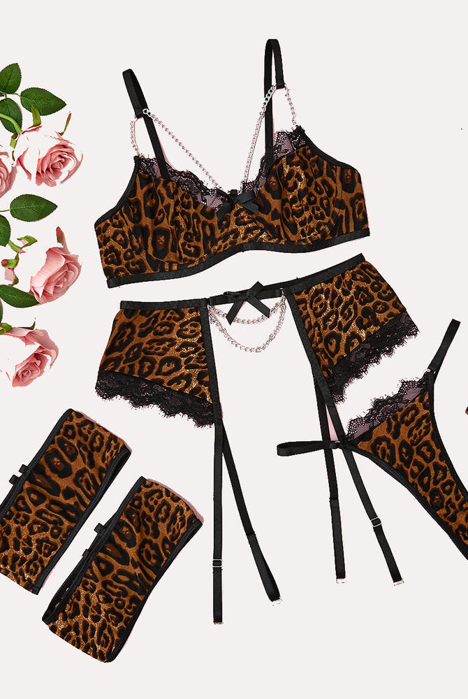 Leopard print lingerie set with chain detail: bra, garter belt, thong, and cuffs.