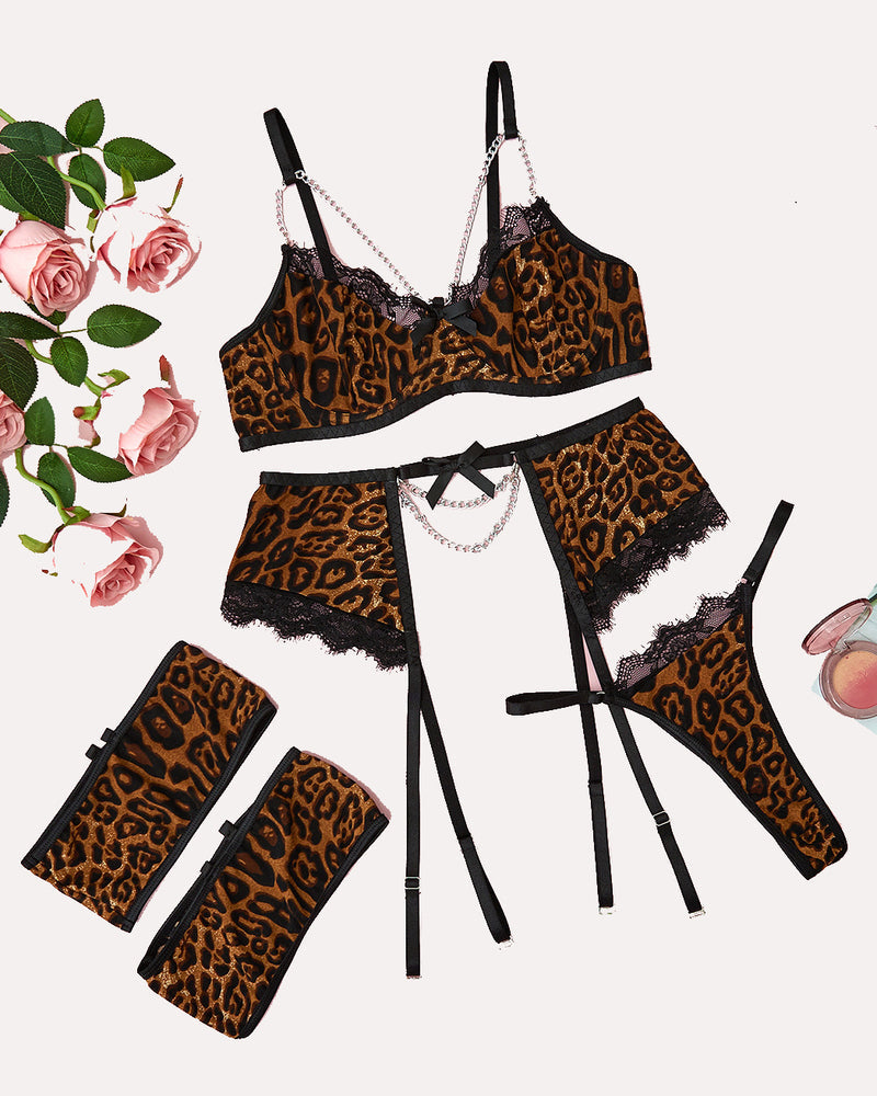 Leopard print lingerie set with chain detail: bra, garter belt, thong, and cuffs.