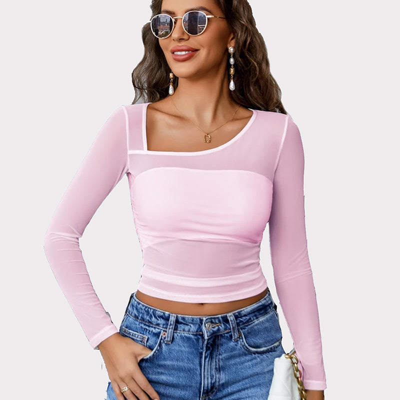 Pink mesh asymmetrical crop top with long sleeves, unique neckline, and denim jeans.