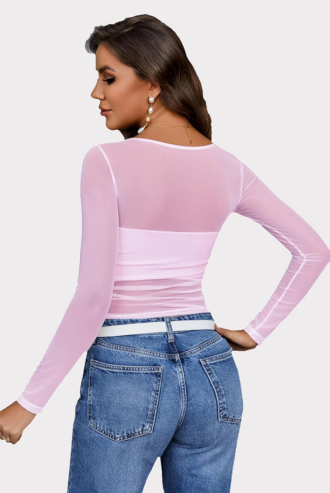 Pink mesh asymmetrical crop top with long sleeves and denim jeans. See-through top from Avidlove.