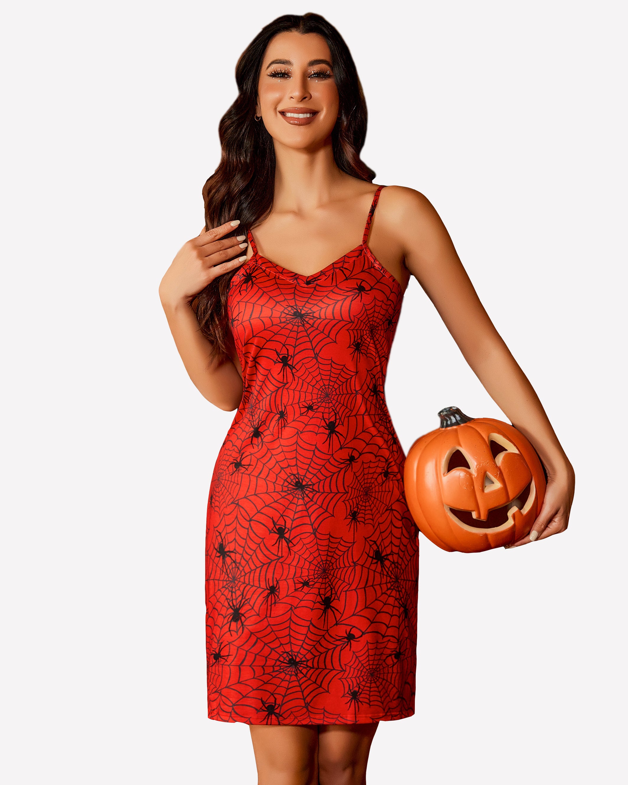 Red spiderweb print chemise dress with spaghetti straps, woman holding jack-o'-lantern