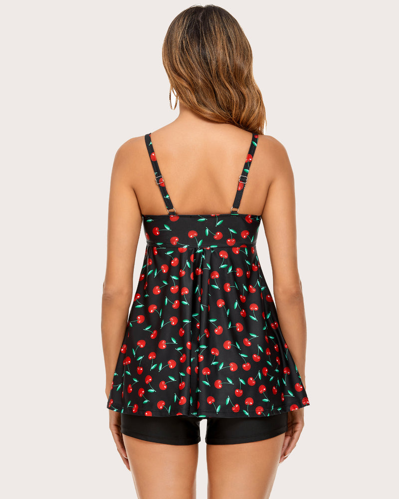Retro cherry print tankini with black swim shorts. Adjustable straps, sun-protective swimwear.