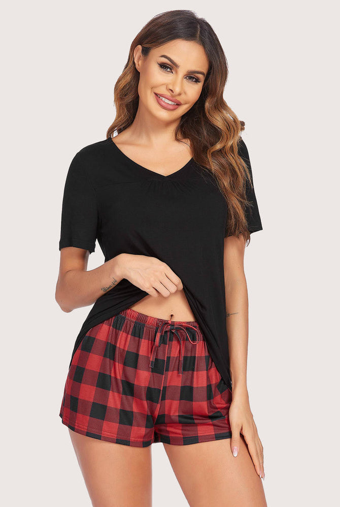 Black V-neck top and red plaid shorts pajama set for women. Comfortable sleepwear.