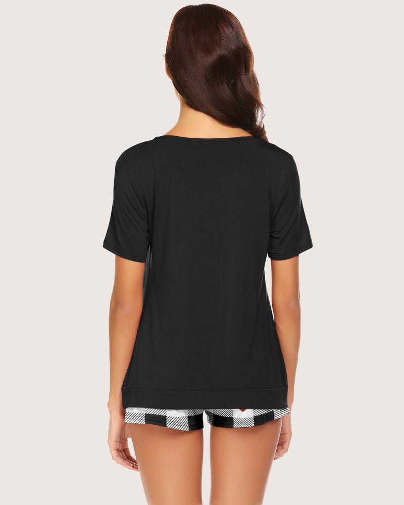 Women's black pajama top and checkered shorts set, soft, comfortable loungewear.