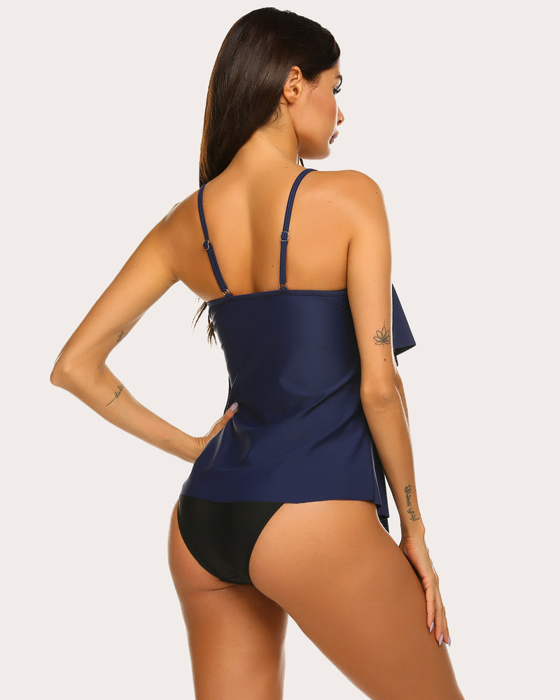 Navy blue ruffle tankini swimsuit with adjustable straps. Layered design, beachwear ready.
