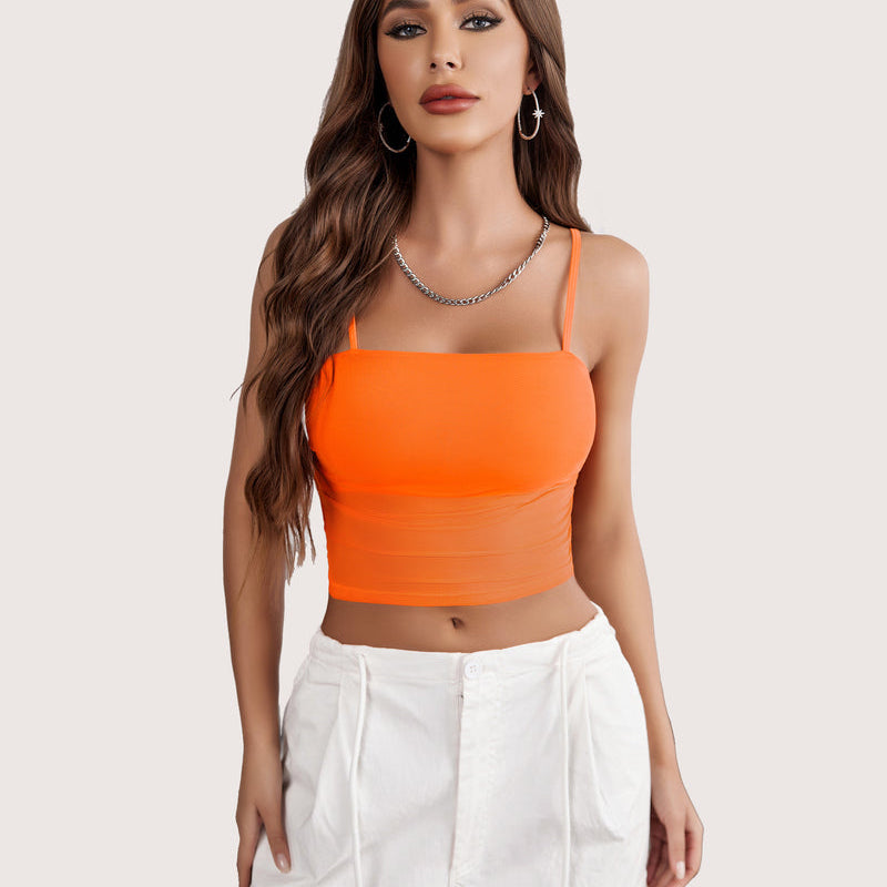 Orange mesh spaghetti strap tank top, layered design, paired with white pants, flattering fit.