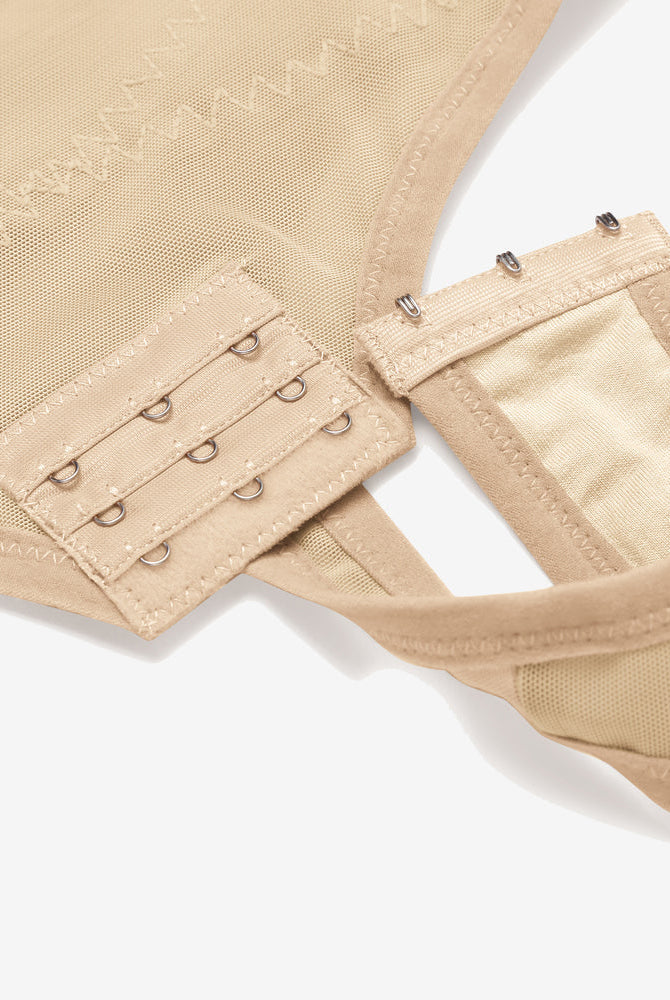 Beige tummy control shapewear: detailed view of hook closure, mesh fabric, high-waisted design