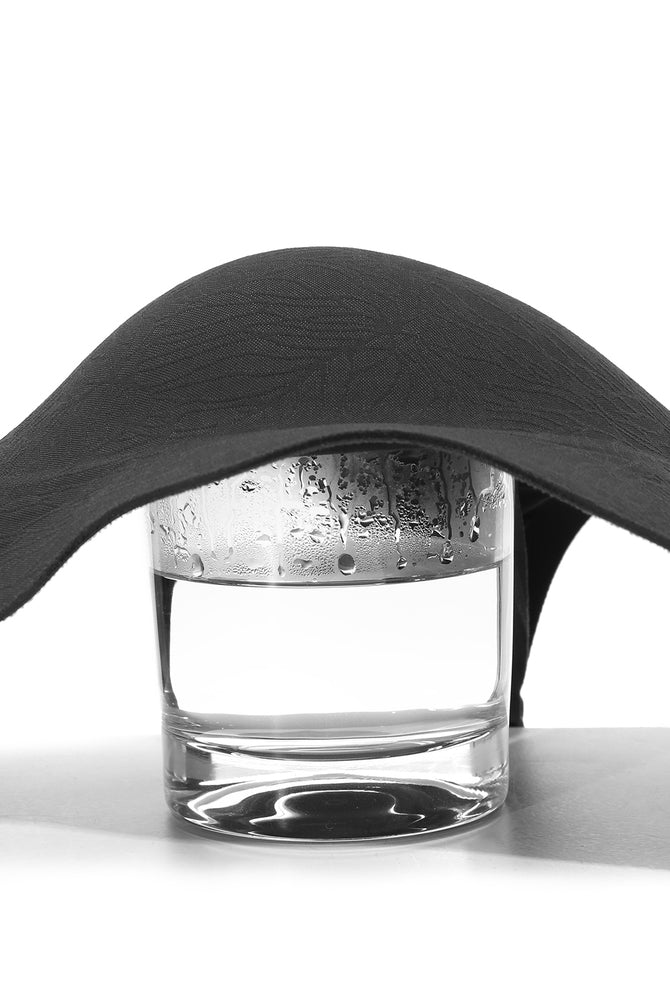 Black seamless maternity nursing bra over water glass, showing breathable, lightweight material.