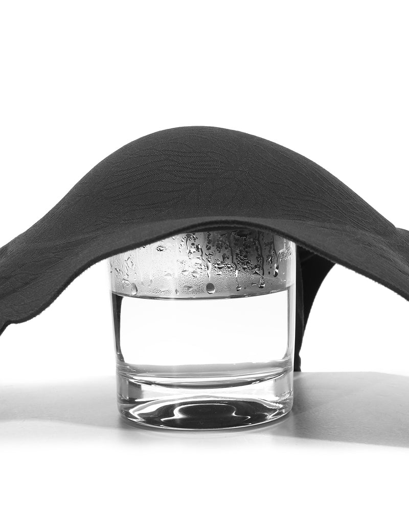 Black seamless maternity nursing bra over water glass, showing breathable, lightweight material.