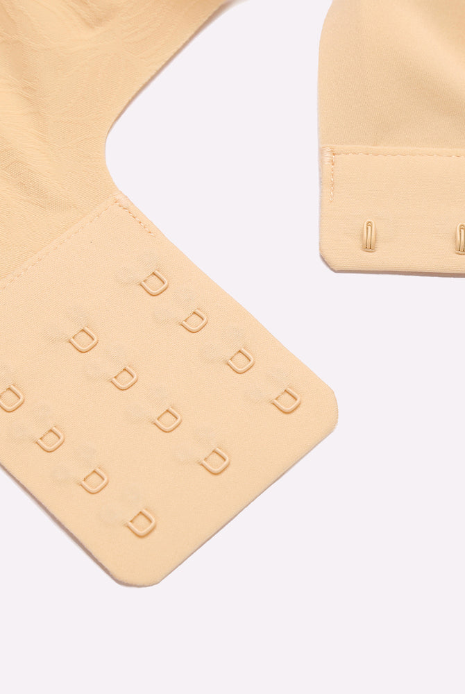 Beige seamless maternity nursing bra with adjustable hook-and-eye closure, nursing bra details