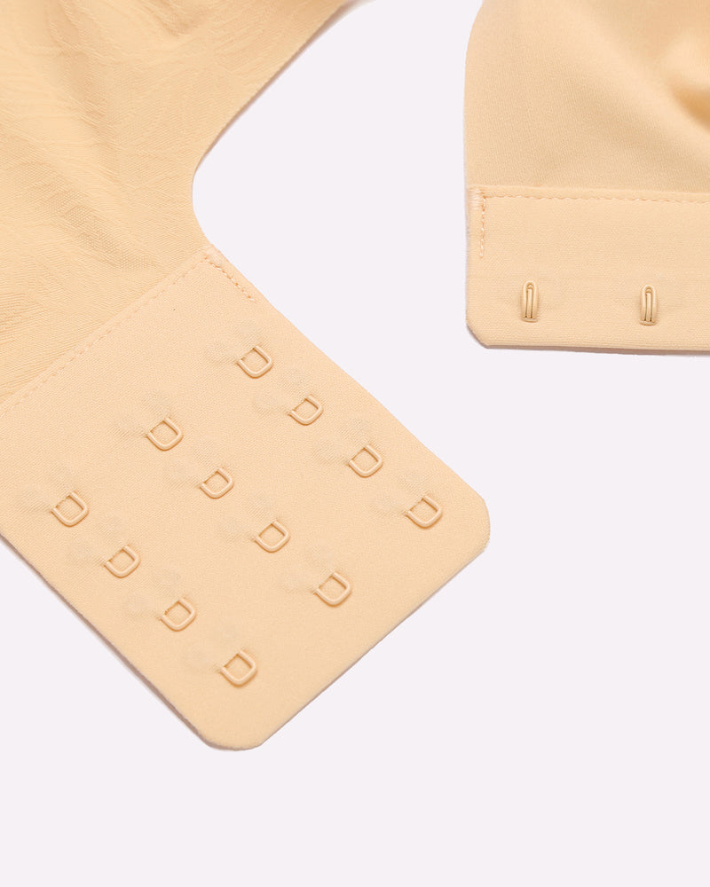 Beige seamless maternity nursing bra with adjustable hook-and-eye closure, nursing bra details