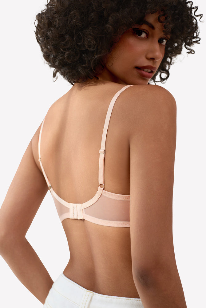 Light pink unlined strappy bra with underwire support and see-through design. Sexy lingerie.