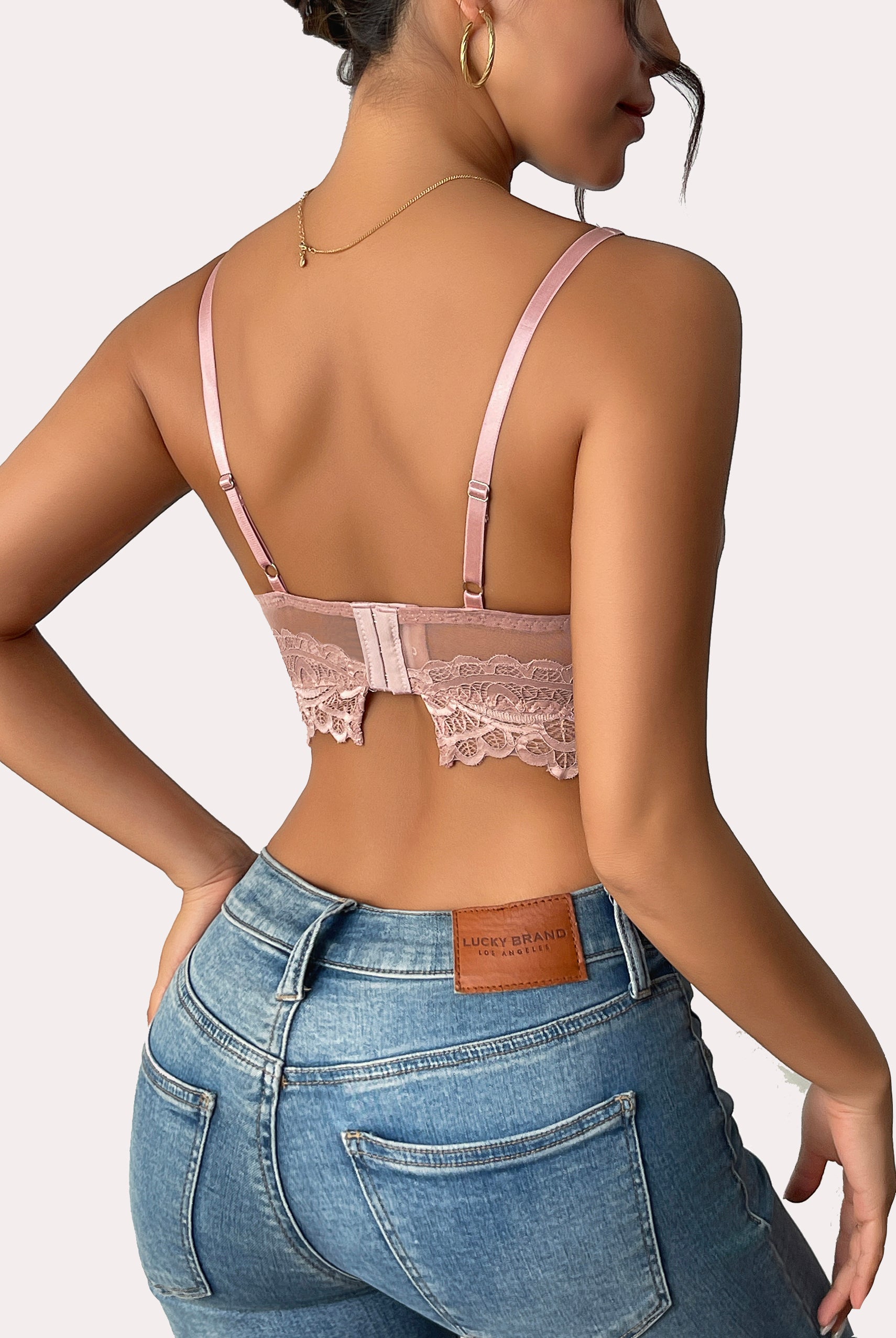Pink lace bralette with adjustable straps and jeans. Sexy lingerie.