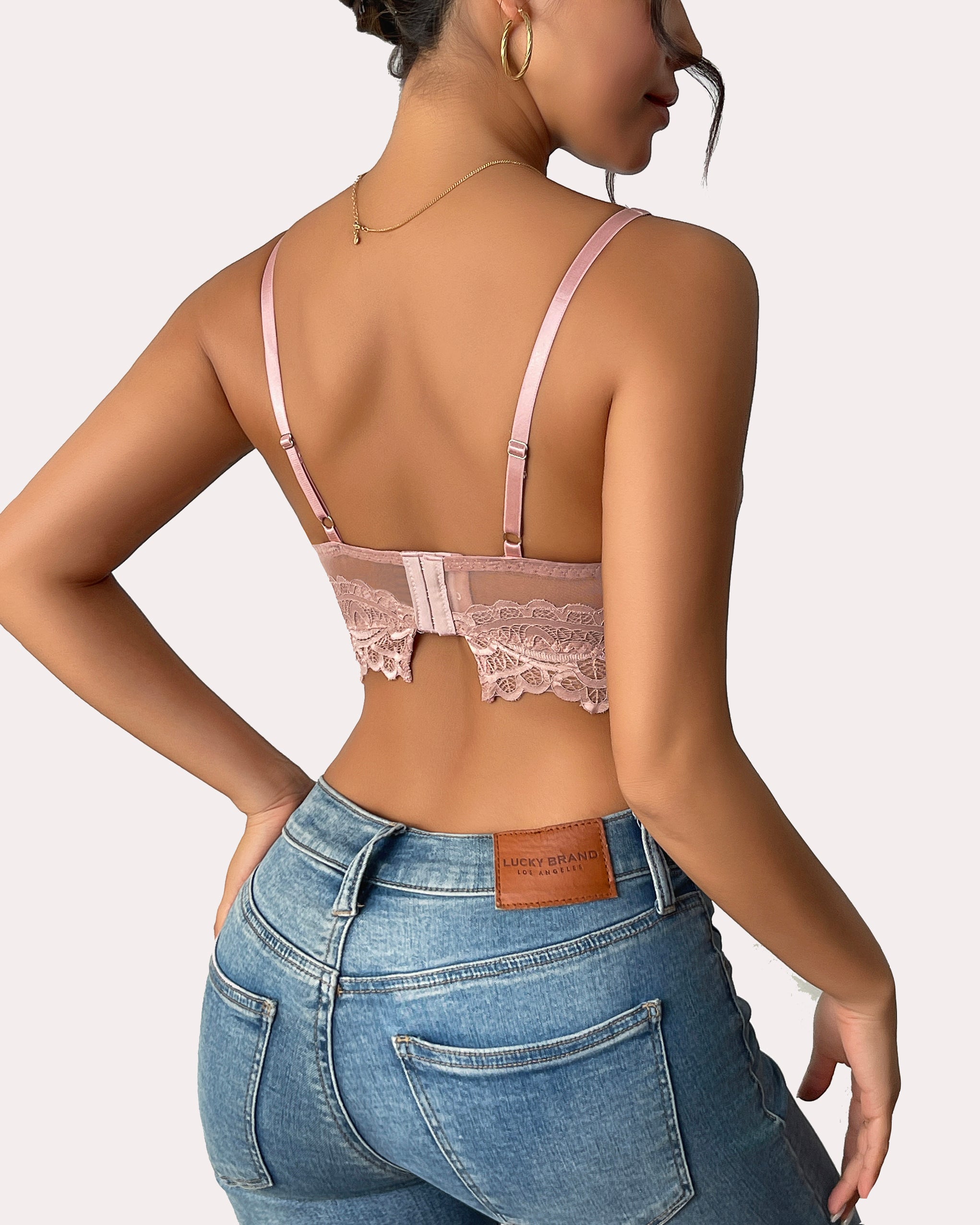 Pink lace bralette with adjustable straps and jeans. Sexy lingerie.