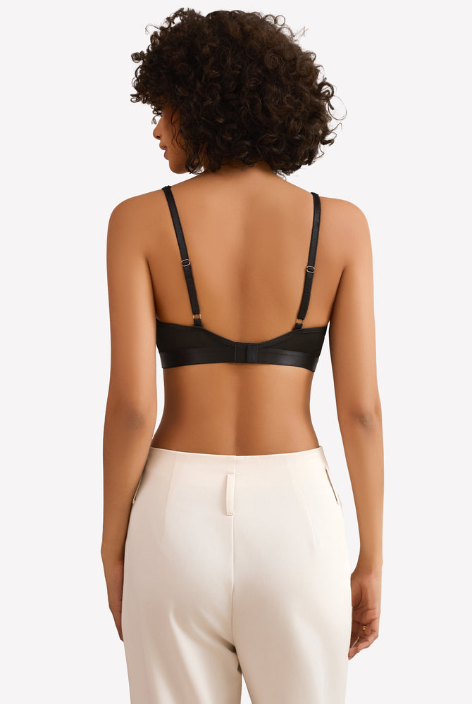 Black wireless bralette with adjustable straps, paired with white pants, for everyday wear.