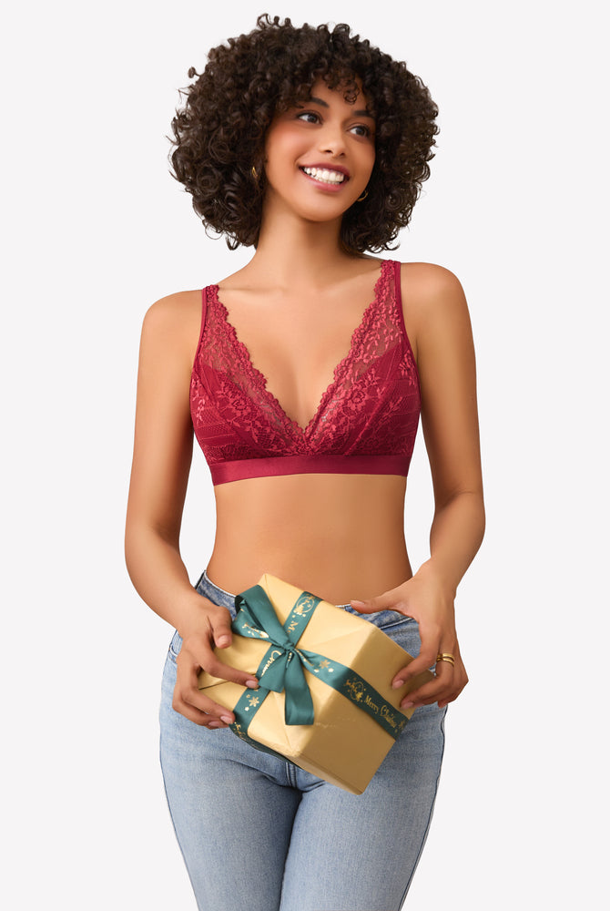 Burgundy lace bralette with adjustable straps, holding gift with Merry Christmas ribbon
