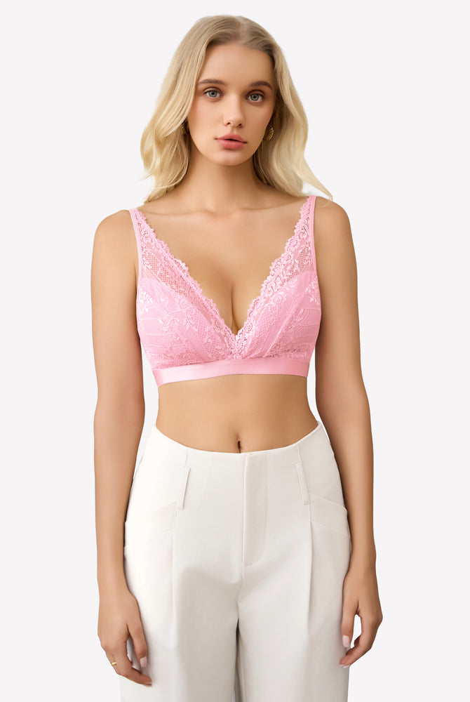 Pink lace wireless bralette with adjustable straps and floral lace, paired with white pants.