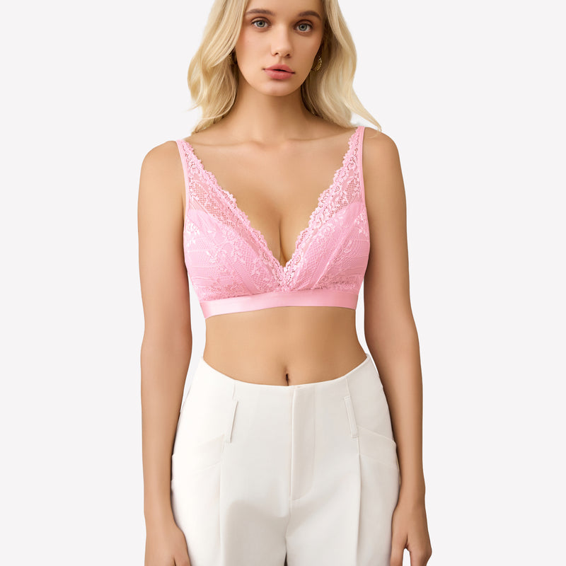 Pink lace wireless bralette with adjustable straps and floral lace, paired with white pants.