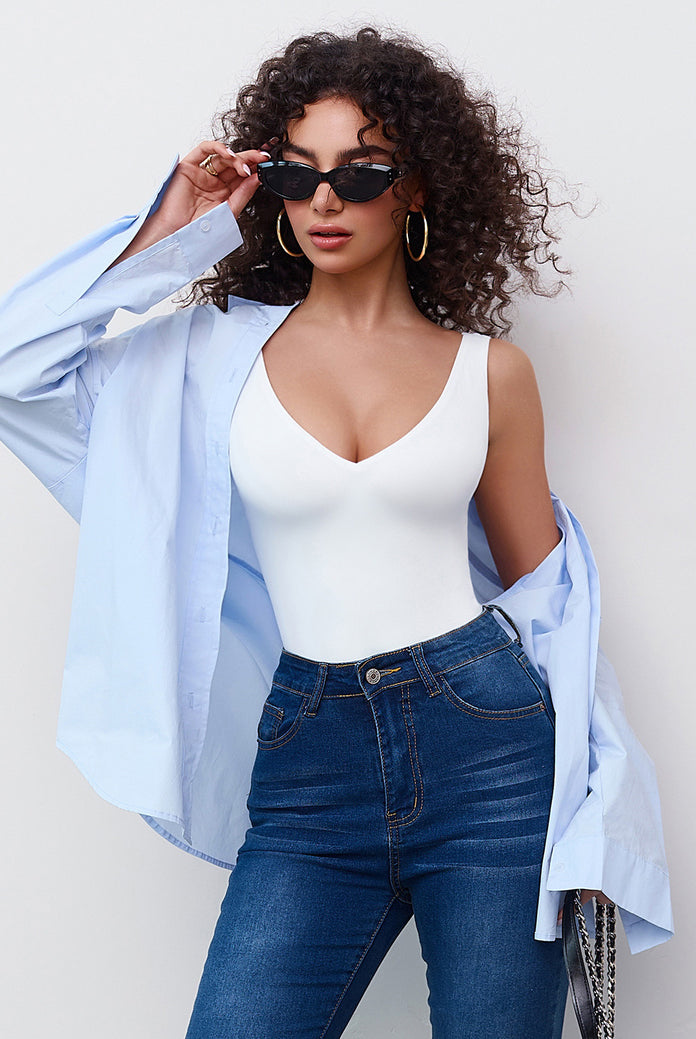 White plunging V-neck bodysuit leotard with blue jeans, a must-have for your wardrobe.