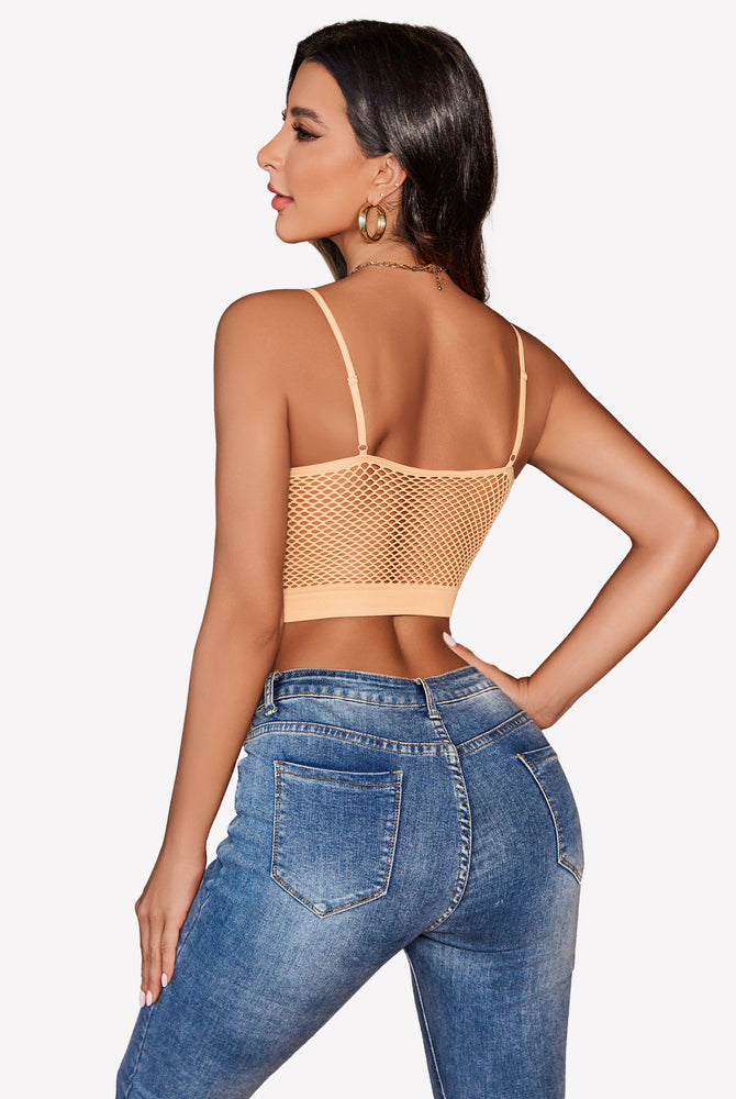 Peach fishnet crop top bralette with blue jeans, showing attractive curves. Y2k lingerie.