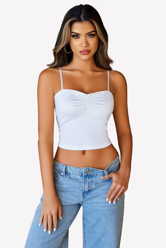 White ruched camisole crop top with adjustable straps and light blue jeans, a cute outfit for women.