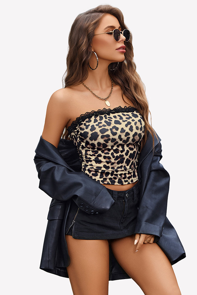 Leopard print strapless tube top, black denim shorts, and leather jacket. Stylish look.