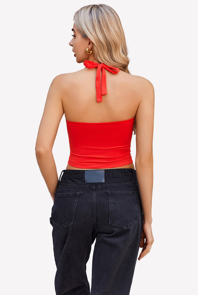 Red halter crop top with backless design, paired with black denim jeans. Perfect for going out.