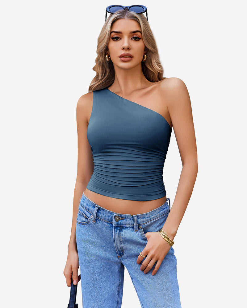Teal one-shoulder tank top with ruched design, paired with light blue jeans. Stylish crop top.