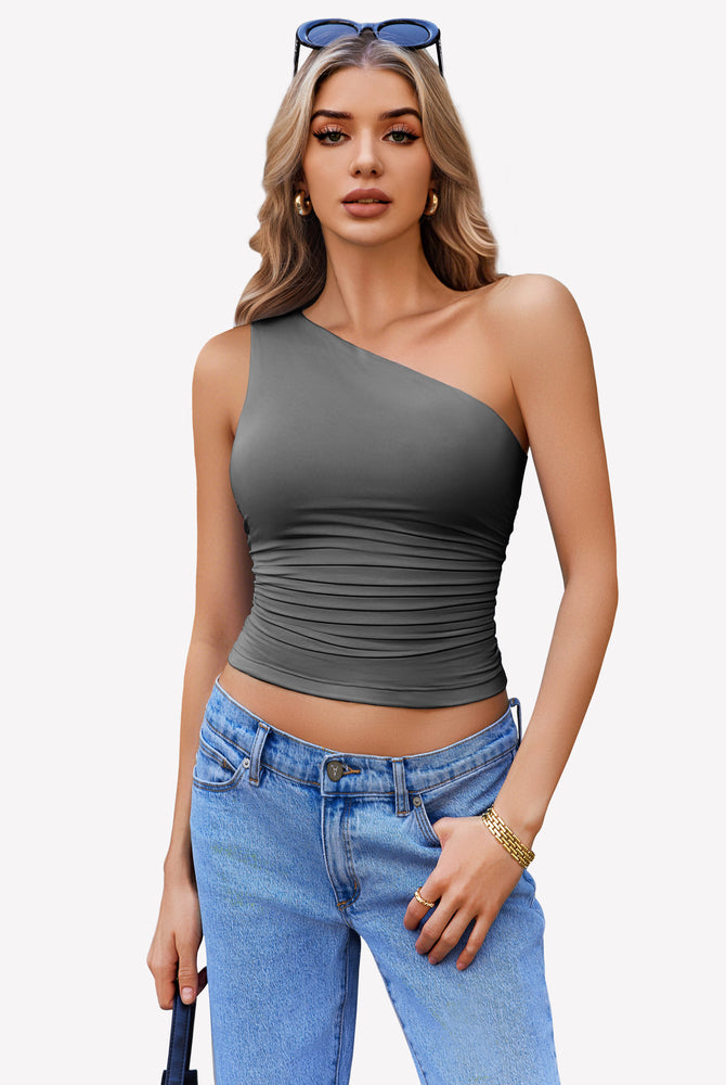 Dark gray one-shoulder tank top with ruched detail, paired with blue jeans. Stylish crop top.