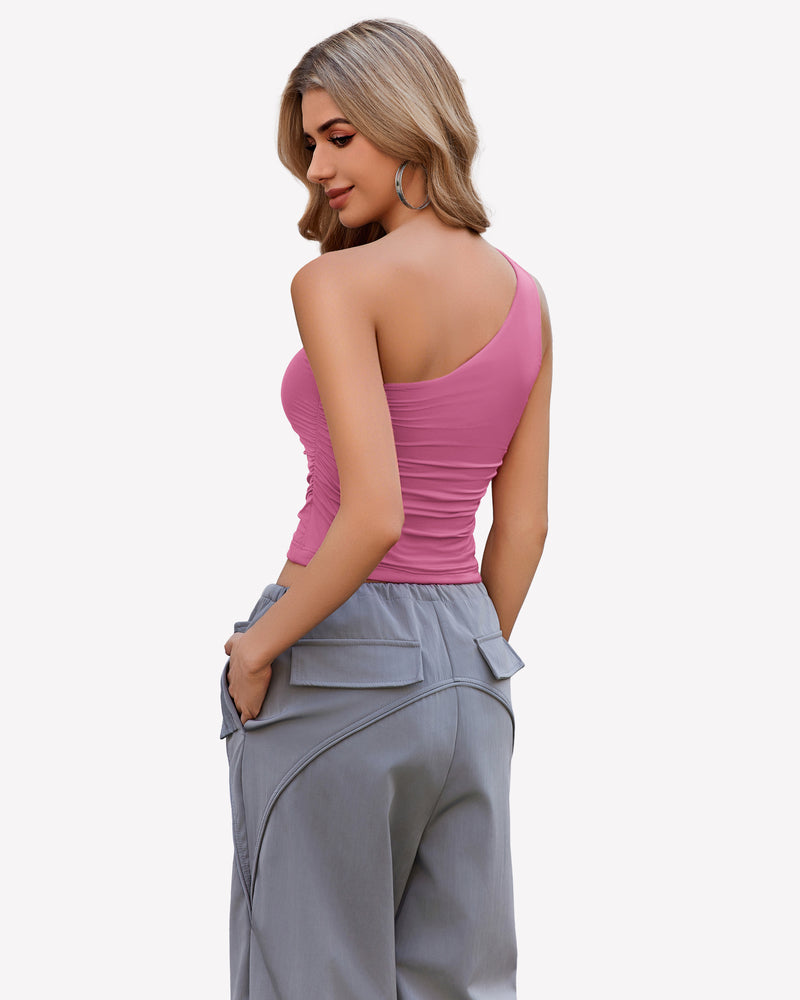 Pink one-shoulder crop top with ruched detail and gray cargo pants. Stylish and casual outfit.