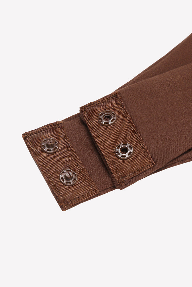 Brown thong bodysuit strap close-up with metal snap adjustment