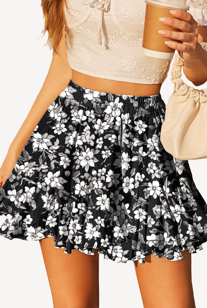 Floral skater skirt with white flowers, black background, elastic waist, stylish summer outfit.