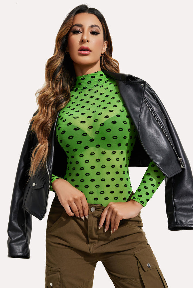 Green mesh bodysuit with black lip pattern, leather jacket, and cargo pants. Sexy lingerie.