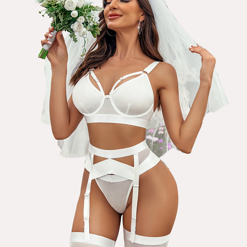 White bridal lingerie set with garter, bra, panties, and straps for a special occasion.