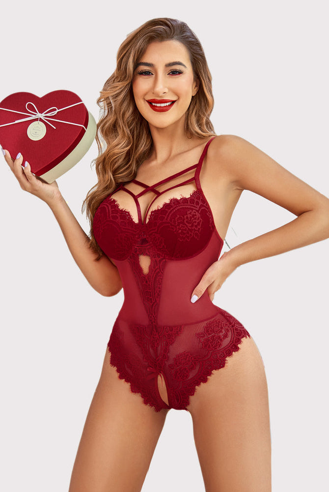 Burgundy lace harness bodysuit with heart box, cut-out detail. Confident, sensual lingerie design.
