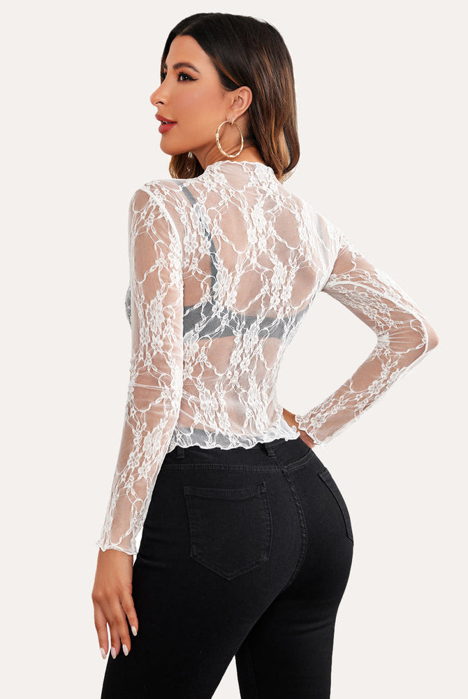 White floral lace sheer blouse with mock neck and long sleeves on a woman, sexy mesh top