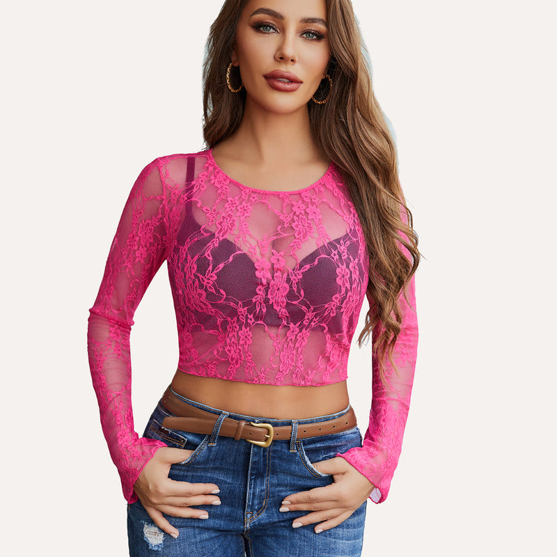 Hot pink floral lace sheer crop top with long sleeves, blue jeans, and brown belt. Classy and sexy.