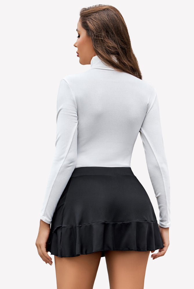 Stylish woman in black pleated mini skirt, white turtleneck, and ruffle detail for confident women.