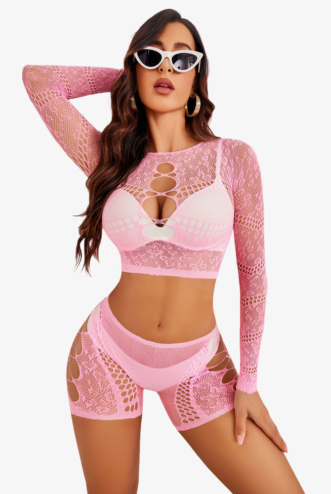 Pink fishnet lingerie set with cutouts, crop top and shorts; a confident, stylish look.