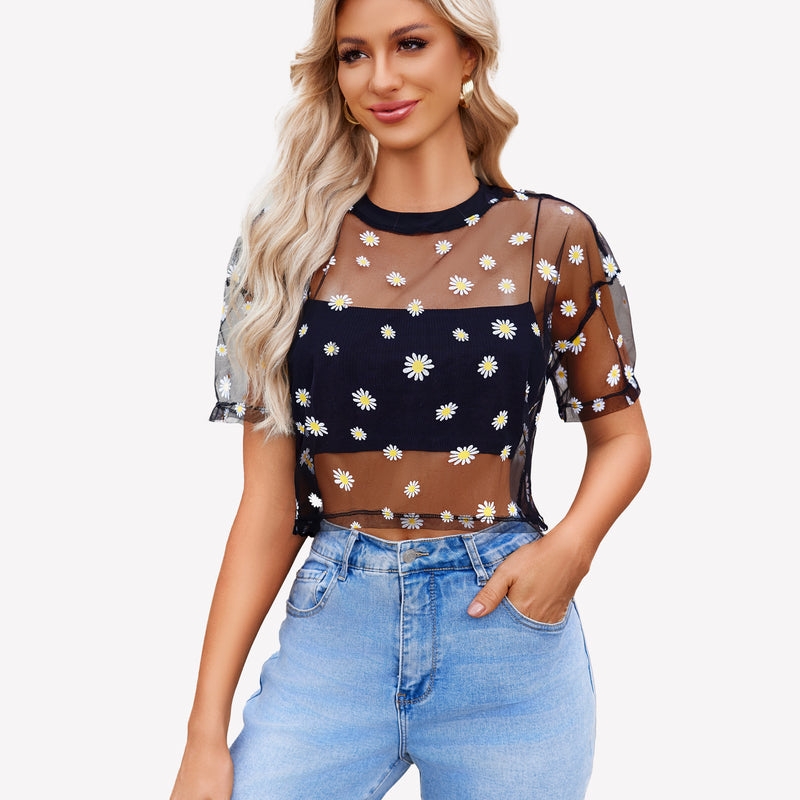 Black daisy mesh crop top, paired with denim jeans. Trendy see-through shirt for women.