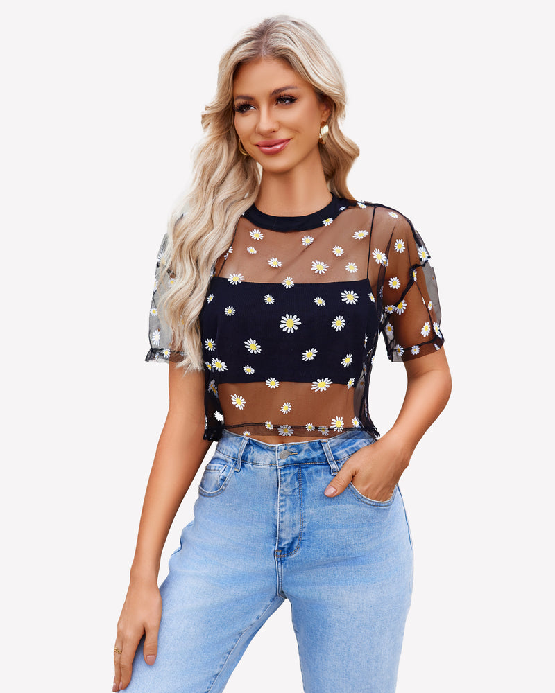 Black daisy mesh crop top, paired with denim jeans. Trendy see-through shirt for women.