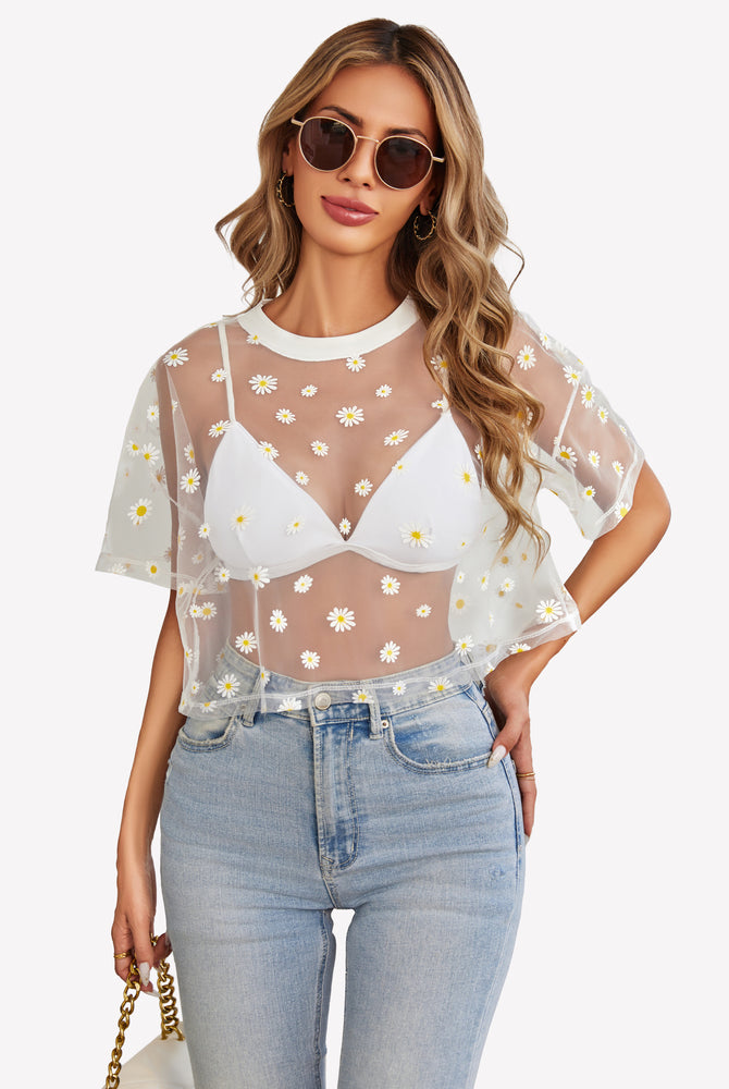 White daisy mesh crop top, light blue denim jeans. Trendy and sexy see-through outfit.