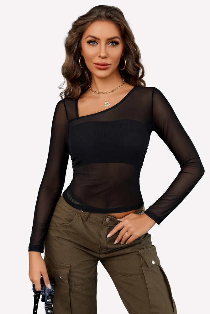 Black sheer crop top with asymmetrical neckline and mesh layer, olive green pants.