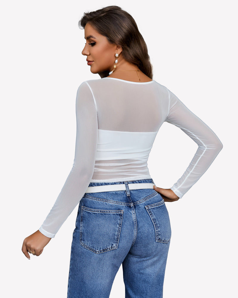 White mesh crop top with asymmetrical neckline, paired with denim jeans. Stylish see-through top.