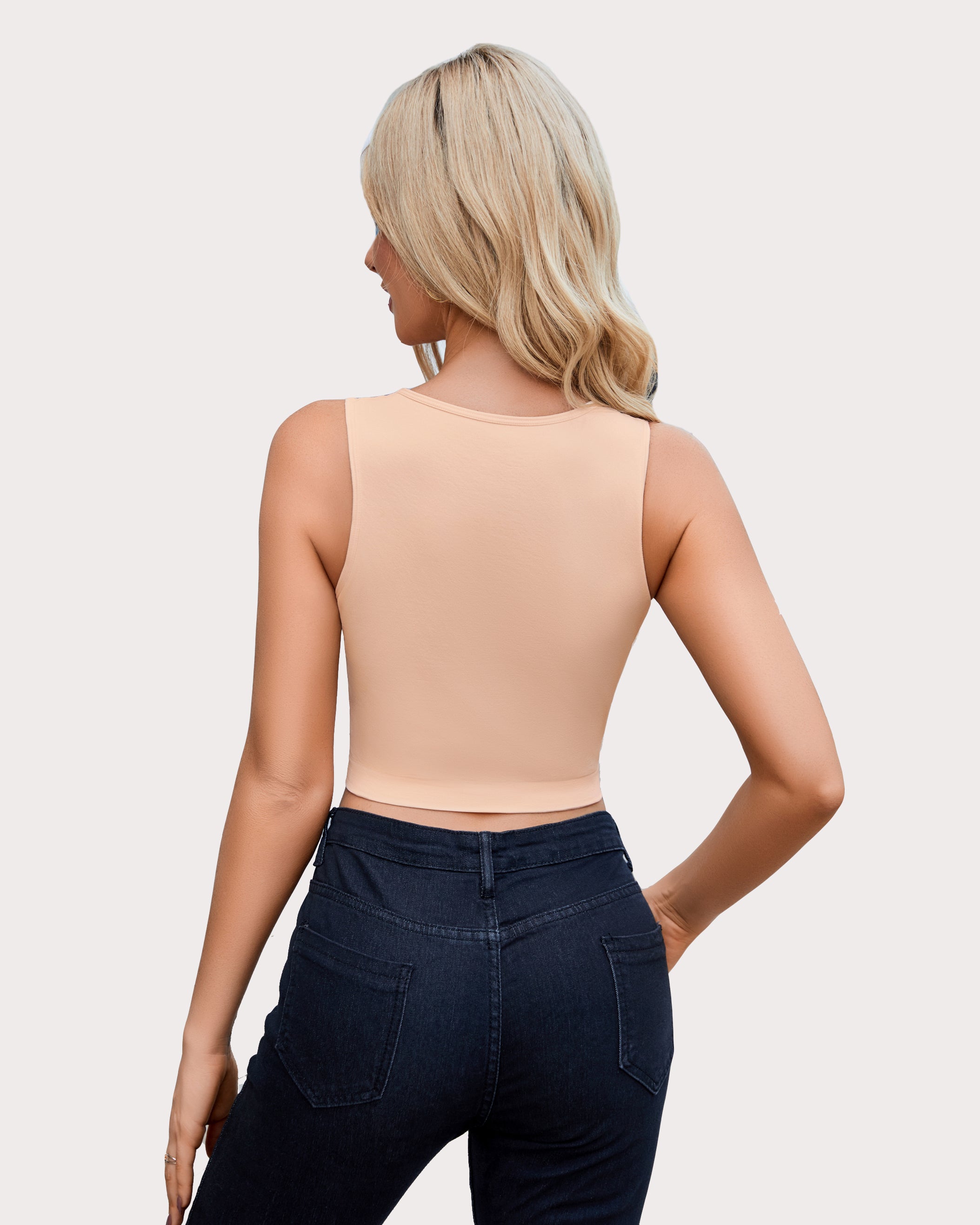 Beige crop top and dark denim jeans, fashionable look for women, showing the model's figure.