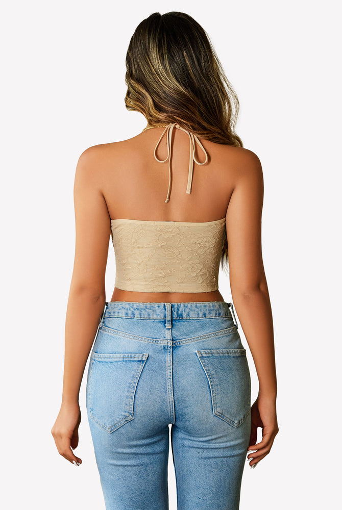 Beige lace halter crop top, Y2k style, with blue jeans. Adjustable straps and flattering fit.