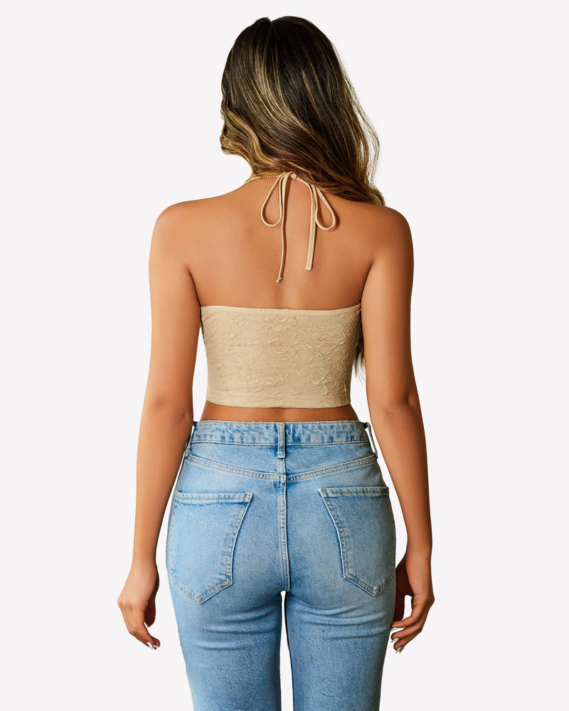 Beige lace halter crop top, Y2k style, with blue jeans. Adjustable straps and flattering fit.