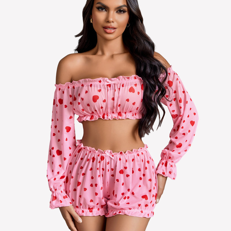 Pink heart-print off-shoulder lingerie set. Ruffle trim, long sleeves, and bow detail.
